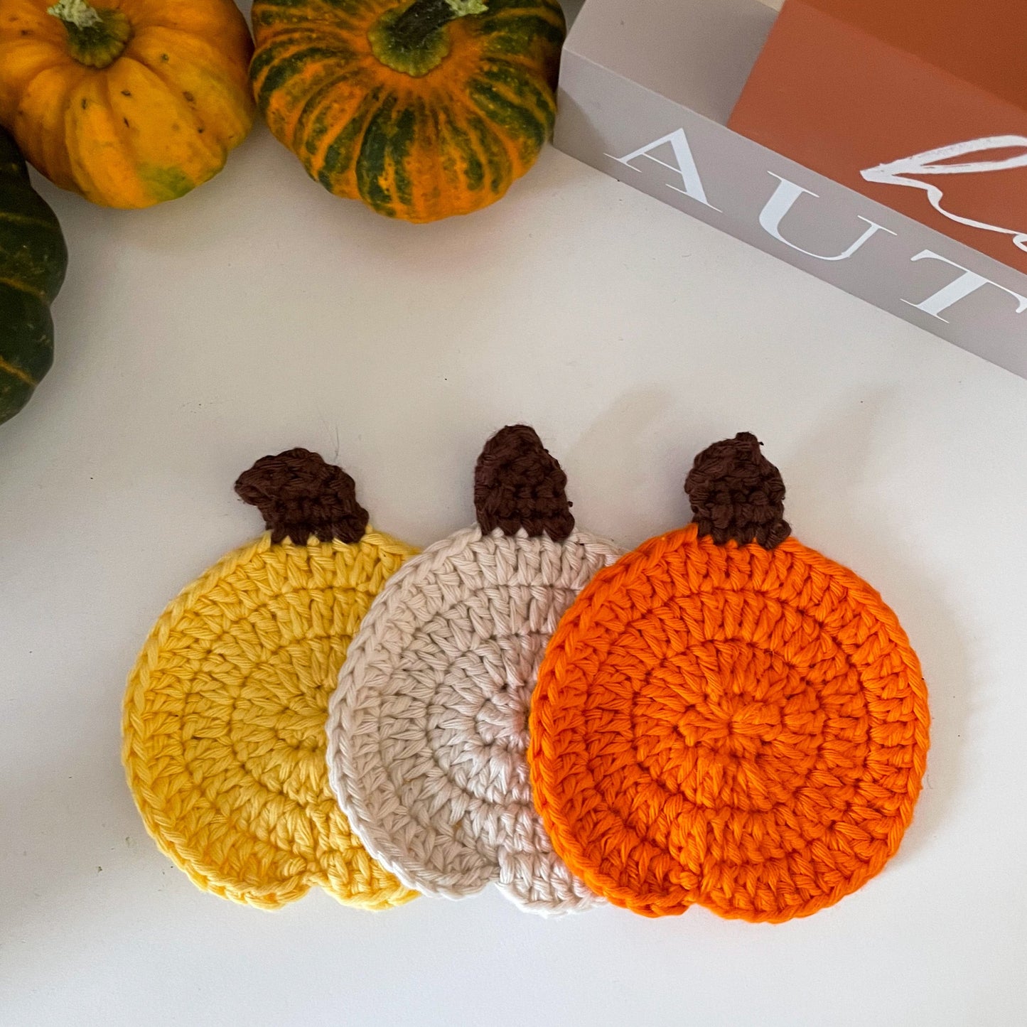 crochet pumpkin coasters in yellow, white and orange